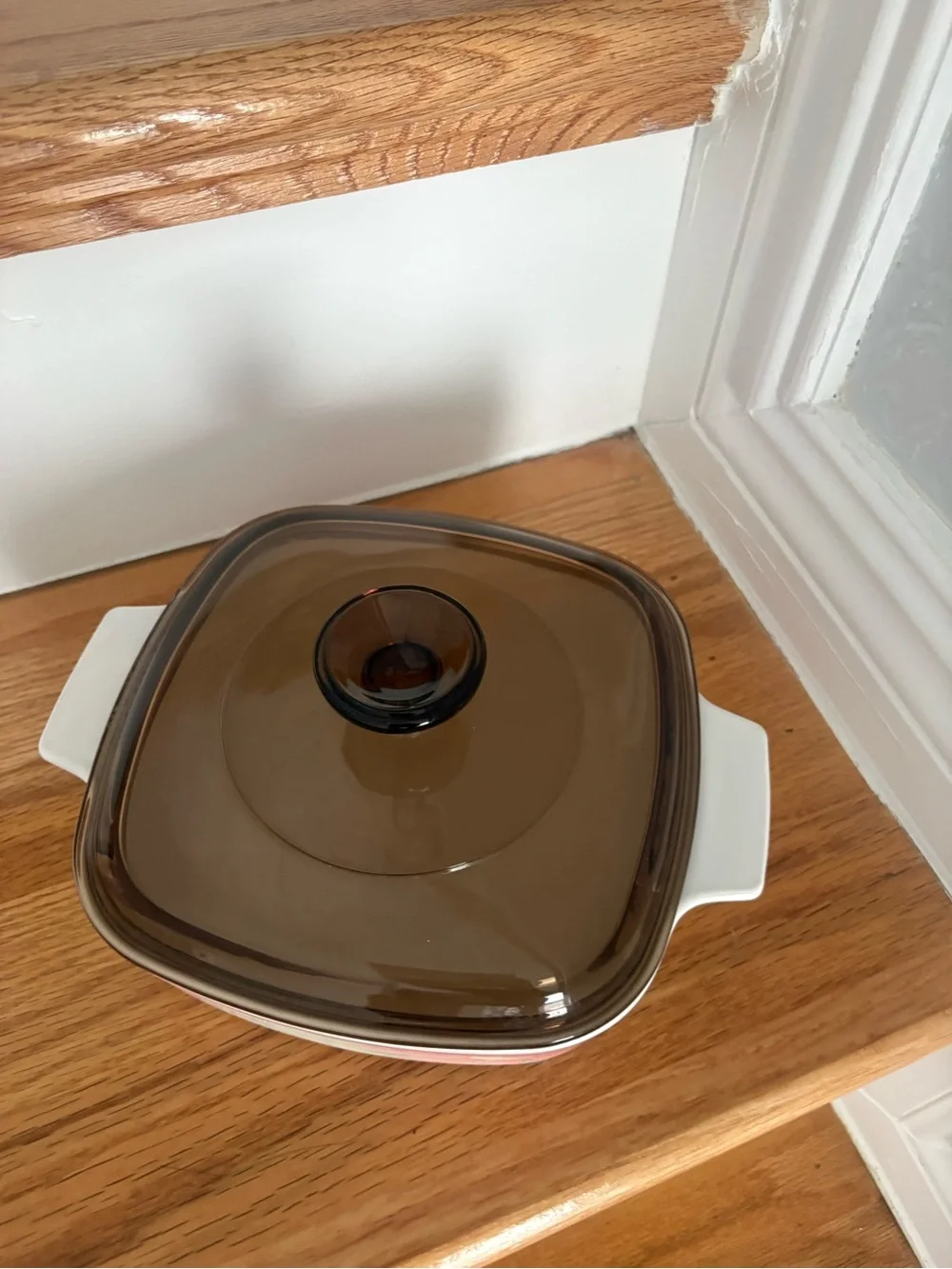 A vintage Corning Ware casserole dish in the Peony Floral pattern with lid